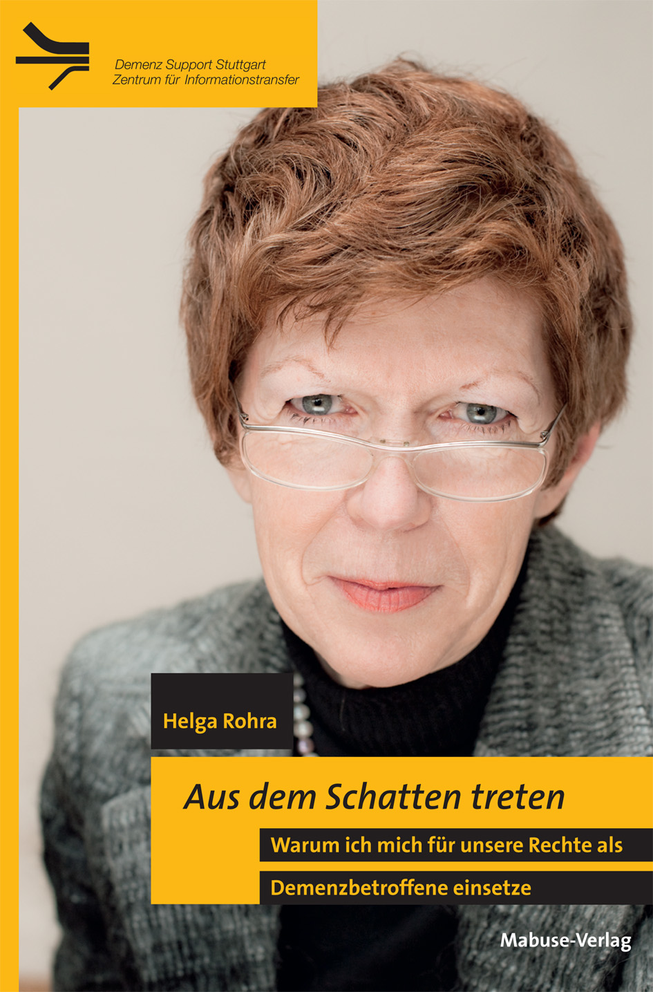 Cover_Aus_dem_Schatten Buchvover auf dem die Autorin Helag Rohra zu sehen ist. Sie trägt kurze braune Haare und eine Brille