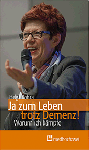 Das Cover zeigt die Autorin bei einem Vortrag. Sie trägt kurze braune Haare, eine Brille und spricht in ein Mikrophon