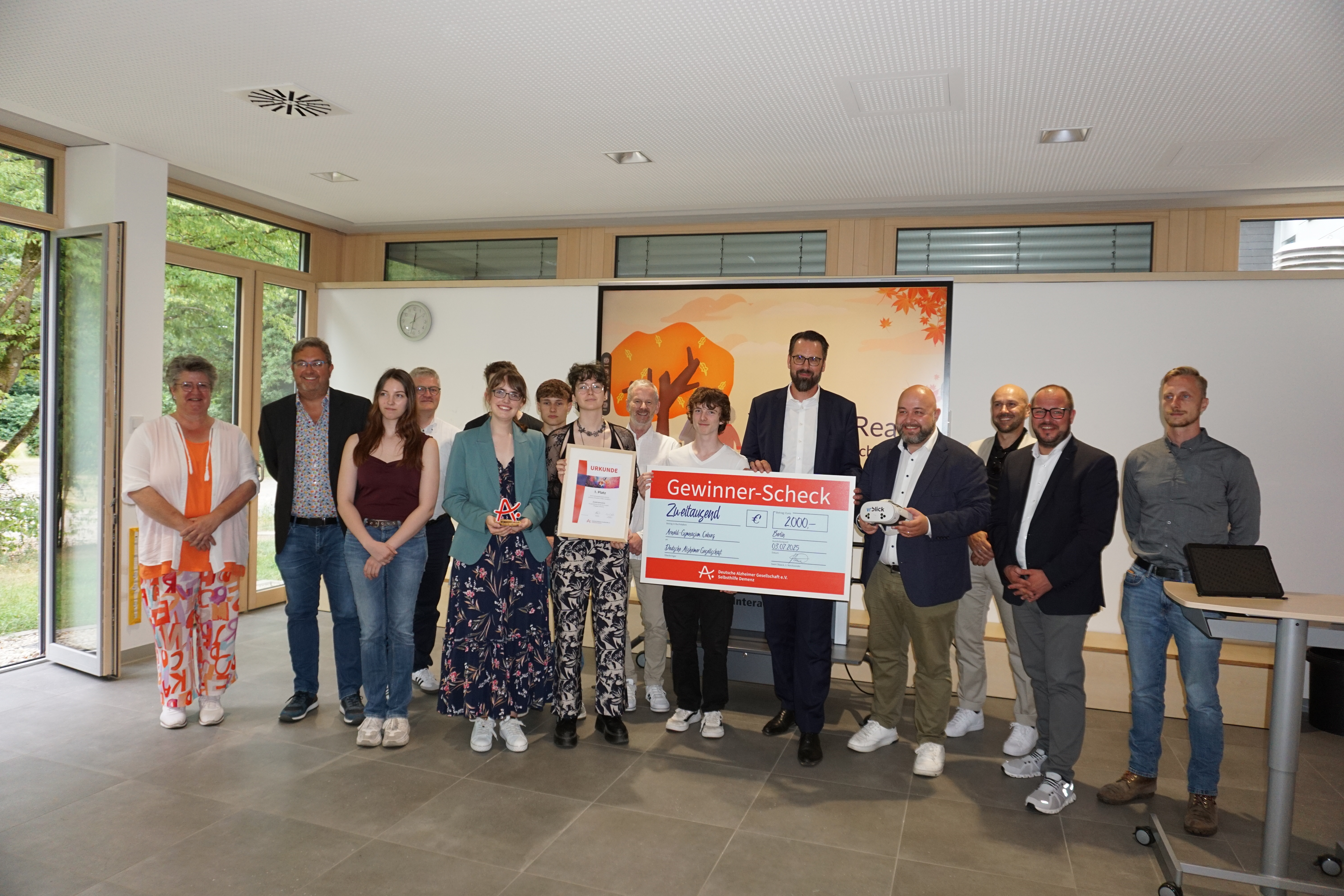 Gruppe der Gewinnerinnen und Gewinner halten den symboischen Scheck in den Händen