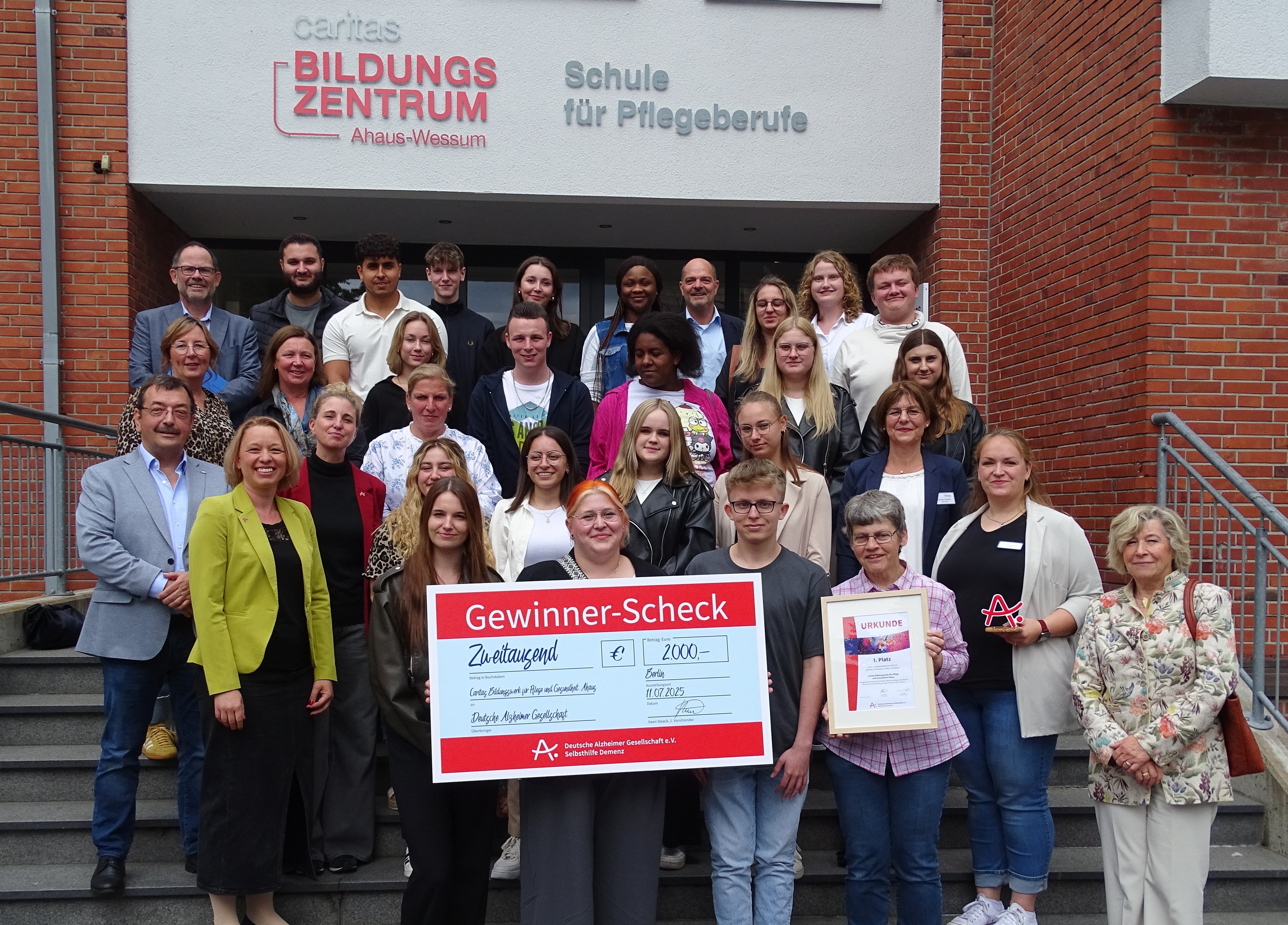 Gruppe der Gewinnerinnen und Gewinner auf der Treppe vor dem Schulgebäude