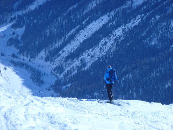 Ein Foto von einem Skifahrer der den Ausblick in den Bergen genißet